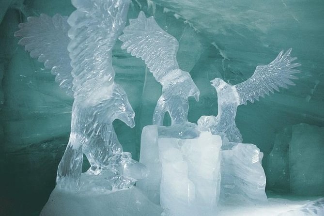 Eagles carved from clear ice, wings spread, in a hall cut into a glacier